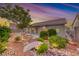 Beautifully landscaped backyard with a stone bridge and lush, desert-friendly plants at 1643 Silver Slipper Ave, Henderson, NV 89002