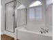 Bathroom featuring a soaking tub with showerhead and bright natural light through the window at 1643 Silver Slipper Ave, Henderson, NV 89002
