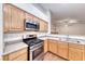 Kitchen with stainless appliances, light wood cabinetry and view to living area at 1643 Silver Slipper Ave, Henderson, NV 89002
