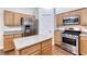 Kitchen with island, stainless steel appliances and light wood cabinets at 1643 Silver Slipper Ave, Henderson, NV 89002