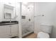Modern bathroom with a dark vanity, and a shower featuring a mosaic tile accent and new fixtures at 1700 Sweeney Ave, Las Vegas, NV 89104