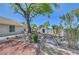 Large backyard with stone path, storage shed, mature trees, and rock landscaping at 1705 Westwind Rd, Las Vegas, NV 89146
