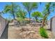 Backyard with mature trees, rock landscaping, and perimeter block wall at 1705 Westwind Rd, Las Vegas, NV 89146