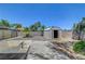 Large backyard with a storage shed, palm trees, desert landscaping, and block wall fence at 1705 Westwind Rd, Las Vegas, NV 89146