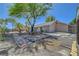 Backyard with stone walkways, desert landscaping, a large shade tree, and a single-story home at 1705 Westwind Rd, Las Vegas, NV 89146