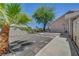 Backyard with palm trees and a storage shed against a block wall on a sunny day at 1705 Westwind Rd, Las Vegas, NV 89146