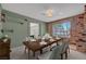 Stylish dining room with a large wooden table, brick accents, and a view into the living area at 1705 Westwind Rd, Las Vegas, NV 89146