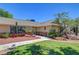 Welcoming facade with mature trees, xeriscaping, and covered entry, creating an inviting curb appeal at 1705 Westwind Rd, Las Vegas, NV 89146