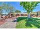Charming home showcasing xeriscaping, mature trees, and lush green grass, perfect for enjoying outdoor desert living at 1705 Westwind Rd, Las Vegas, NV 89146