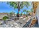 Serene back patio with outdoor seating surrounded by mature trees and rock landscaping at 1705 Westwind Rd, Las Vegas, NV 89146