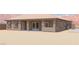 Exterior rear view of single-story home showing desert landscaping, covered patio and outdoor kitchen at 1840 Old West Ave, Pahrump, NV 89048
