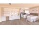 Open kitchen boasts white cabinets, marble countertops, a large island, stainless appliances and bar seating at 1840 Old West Ave, Pahrump, NV 89048