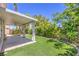 Lush backyard with artificial grass, a covered patio, and green landscaping at 1869 Desert Forest Way, Henderson, NV 89012