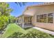 Backyard featuring artificial grass, a covered patio, and tan colored exterior of the house at 1869 Desert Forest Way, Henderson, NV 89012