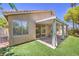 Backyard featuring a covered patio, artificial grass, and a sliding glass door at 1869 Desert Forest Way, Henderson, NV 89012