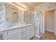 Bathroom with a double vanity with marble countertop, large mirror, walk-in shower, and floral wallpaper at 1869 Desert Forest Way, Henderson, NV 89012