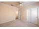 Carpeted bedroom featuring a ceiling fan, white closets, and neutral wall color at 1869 Desert Forest Way, Henderson, NV 89012