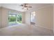 Spacious bedroom featuring a ceiling fan, carpet flooring, and sliding glass doors to the backyard at 1869 Desert Forest Way, Henderson, NV 89012
