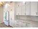 Bright kitchen featuring white cabinets, gold hardware, mosaic backsplash, and stainless steel appliances at 1869 Desert Forest Way, Henderson, NV 89012