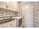 Functional laundry room boasting cabinetry, modern washer and dryer, and rabbit print wallpaper at 1869 Desert Forest Way, Henderson, NV 89012
