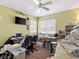 A cluttered bedroom features a ceiling fan, desk, and two windows for natural light at 1870 Desert Forest Way, Henderson, NV 89012