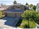 Attractive two-story home with a three-car garage, mature landscaping, and a well-maintained lawn at 1870 Desert Forest Way, Henderson, NV 89012