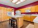 Bright kitchen boasts oak cabinets, white appliances, tiled counters and island seating at 1870 Desert Forest Way, Henderson, NV 89012