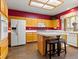 Well-lit kitchen showcases an island with seating, oak cabinets and white appliances at 1870 Desert Forest Way, Henderson, NV 89012