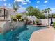 Serene pool area featuring a rock waterfall, lush landscaping, and ample sunlight at 1870 Desert Forest Way, Henderson, NV 89012