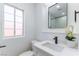 Modern bathroom features a white vanity with a black faucet, matching mirror, and window at 1916 Howard Ave, Las Vegas, NV 89104