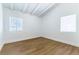 Bright bedroom with wood-look floors has two windows to let in sunlight at 1916 Howard Ave, Las Vegas, NV 89104