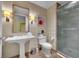 This bathroom features a sink, toilet, sconces and a shower with glass door at 2000 N Fashion Show Dr # 2222, Las Vegas, NV 89109