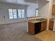 Open kitchen with wood cabinets, laminate countertops, with carpeted living room at 2019 Rancho Lake Dr # 102, Las Vegas, NV 89108