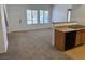 Open kitchen with wood cabinets, laminate countertops, with carpeted living room at 2019 Rancho Lake Dr # 102, Las Vegas, NV 89108