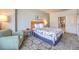 Comfortable bedroom with a queen bed, a cozy chair, and side table at 211 E Flamingo Rd # 402, Las Vegas, NV 89169