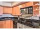 Well-equipped kitchen features wooden cabinets, stainless steel appliances, and black countertops at 211 E Flamingo Rd # 402, Las Vegas, NV 89169
