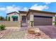 View of the front of a home showcasing desert landscaping, a brick driveway, and gated entry at 2166 Alyssa Jade Dr, Henderson, NV 89052