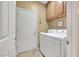 Well-lit laundry room with modern appliances and ample storage space above washer and dryer at 2166 Alyssa Jade Dr, Henderson, NV 89052