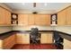 Spacious office featuring custom built-in shelving and cabinets with dark countertops and beautiful hardwood floors at 2166 Alyssa Jade Dr, Henderson, NV 89052