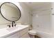 Bathroom with white vanity, dark fixtures, a round mirror, and shower over tub at 2241 Tall Pine Dr, Las Vegas, NV 89108