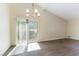 Light-filled dining room with vaulted ceiling, elegant chandelier, and sliding glass door to the backyard at 2241 Tall Pine Dr, Las Vegas, NV 89108