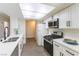 Modern kitchen with white cabinets, quartz counters, stainless steel appliances, and ample natural light at 2241 Tall Pine Dr, Las Vegas, NV 89108