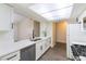 Updated kitchen with stainless steel dishwasher, white cabinets and countertops, and wood-look flooring at 2241 Tall Pine Dr, Las Vegas, NV 89108