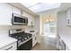 Kitchen with stainless steel oven and microwave and view to dining area and sliding glass door at 2241 Tall Pine Dr, Las Vegas, NV 89108