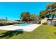 Community pool with manicured landscaping, mature trees, and comfortable lounge chairs offering an inviting outdoor retreat at 2241 Tall Pine Dr, Las Vegas, NV 89108