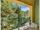 Balcony area with a glass table overlooking lush trees and greenery at 30 Strada Di Villaggio # 227, Henderson, NV 89011