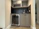 Compact bar area with a mini-fridge, cabinets, and dark backsplash, perfect for entertaining guests at 3142 Bel Air Dr, Las Vegas, NV 89109