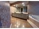 Bathroom with a large mirror, double sinks, and a tub at 3142 Bel Air Dr, Las Vegas, NV 89109