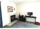 Cozy living room with decorative fireplace, light gray carpet, and a workspace setup at 3150 Soft Breezes Dr # 1192, Las Vegas, NV 89128