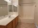Bright bathroom features a large mirror over the vanity and shower-tub combination at 338 Brilliant Summit Cir, Henderson, NV 89052
